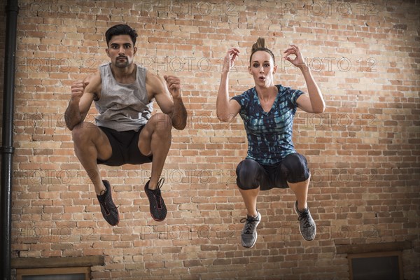 Man and woman jumping in gym