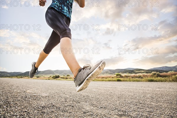 Low section of woman jogging in desert landscape