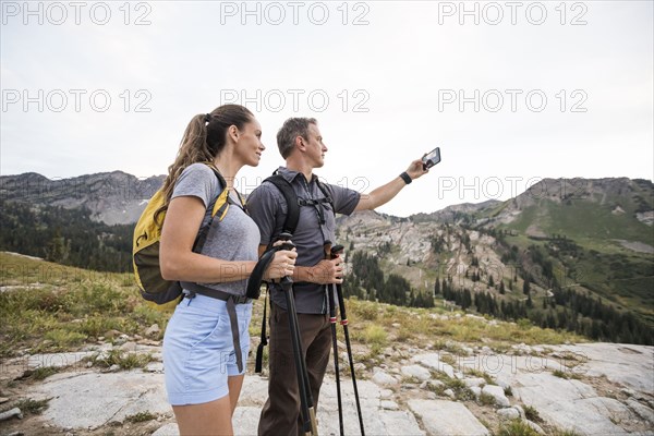 Hiking couple taking selfie in mountains