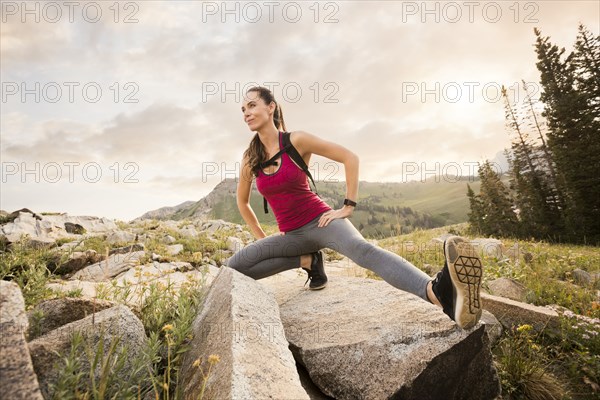 Female hiker stretching in mountains