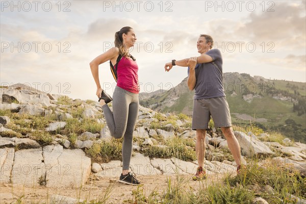 Hiking couple stretching in mountains