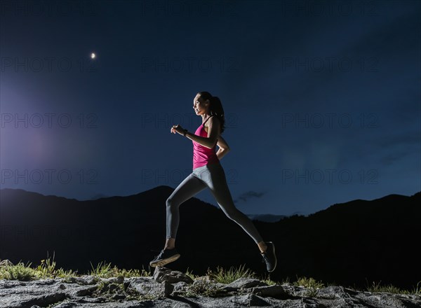 Woman jogging in mountains at night