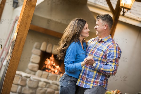 Mature couple dancing by fireplace