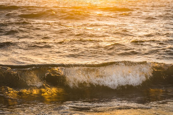Ocean waves splashing at sunset