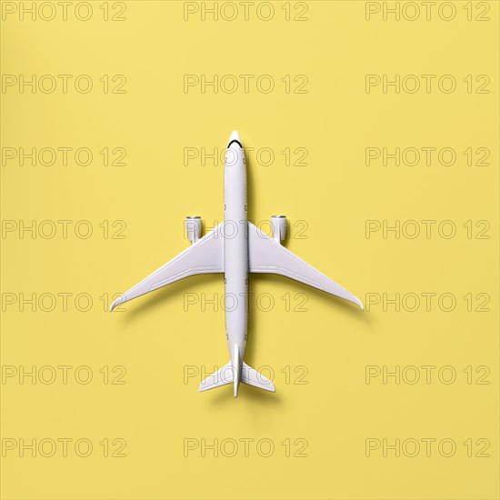 Overhead view of airplane model against yellow background