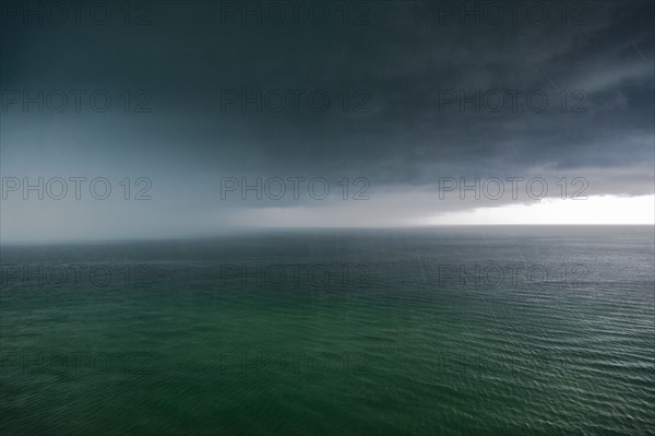 Thunder storm clouds and rain over ocean