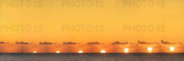 Sequential sun rising above calm ocean