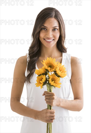 Studio portrait of smiling woman holding bunch of sunflowers