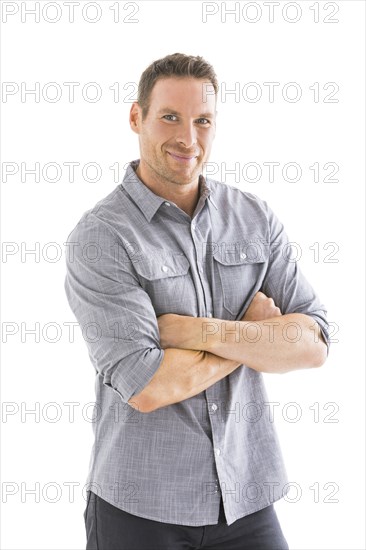 Studio portrait of smiling man with arms crossed