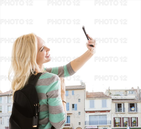 Smiling woman taking selfie in city