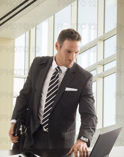 Businessman looking at laptop in office