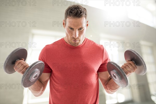 Man exercising with dumbbells in gym