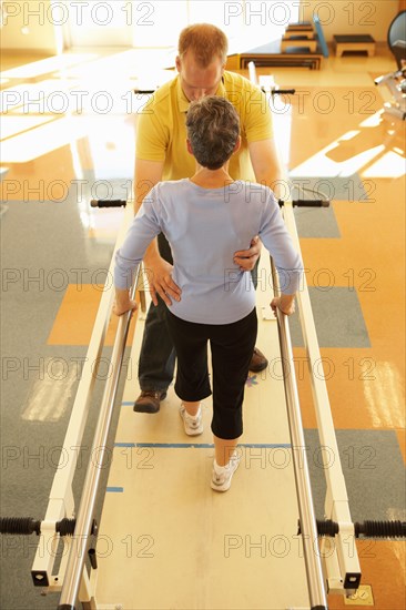 Physical therapist with patient in gym