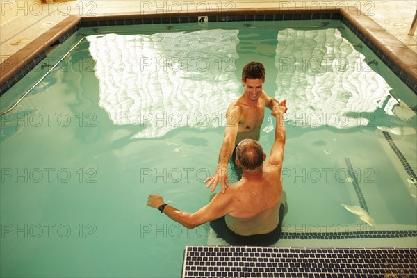 Physical therapist working with patient in swimming pool