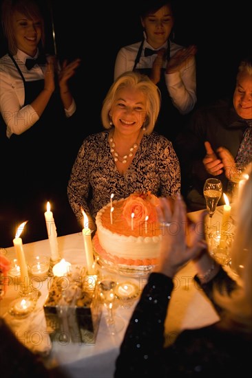 Group of friends celebrating birthday in restaurant