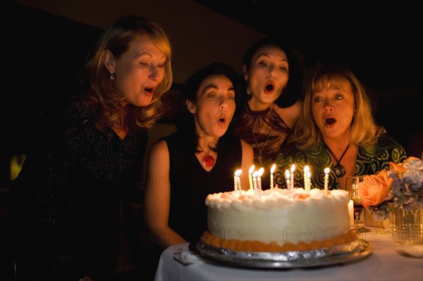 Group of friends celebrating birthday in restaurant