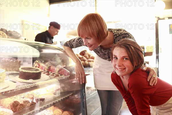 Owner with daughter (10-11) looking at bakery display