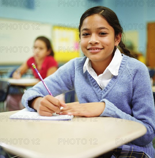 Portrait of girl (12-13) sitting in classroom