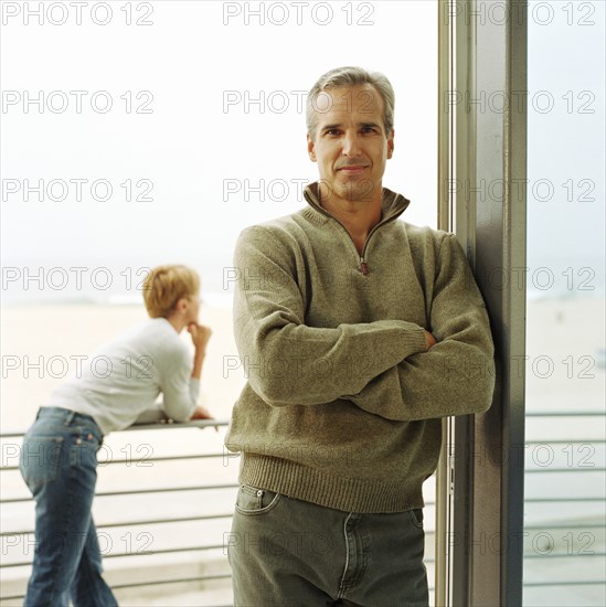 Portrait of man leaning on doorway of house