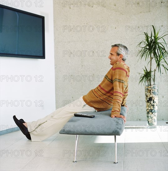 Man watching flat screen TV at home