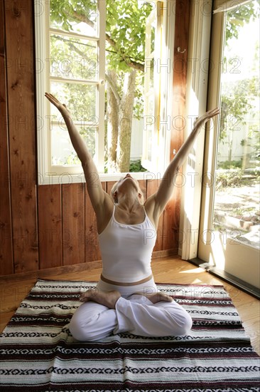 Mature woman practicing yoga at home