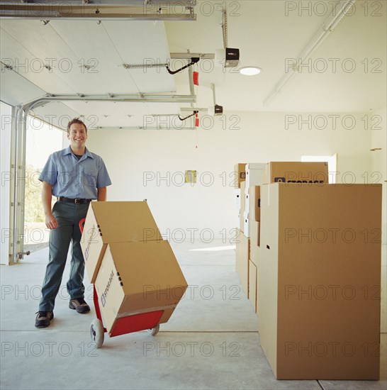 Portrait of man carrying boxes on dolly