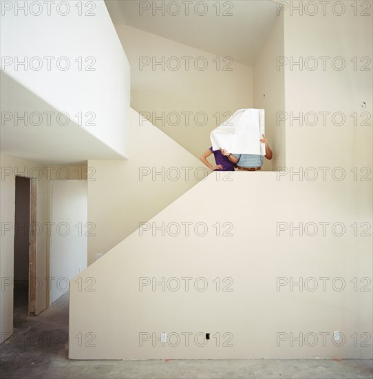 Couple in new home looking at blueprints