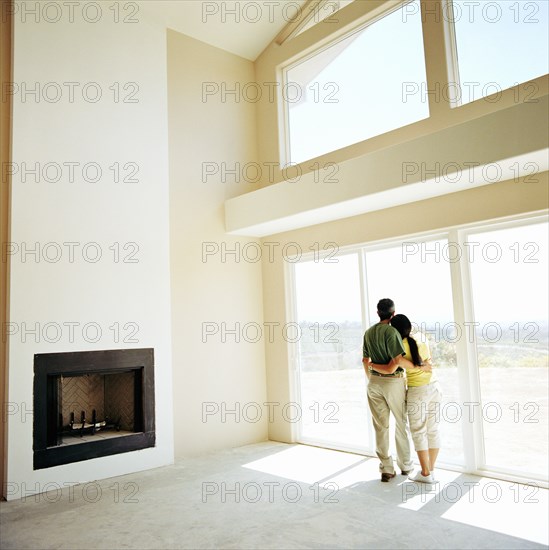 Couple embracing in living room of new home