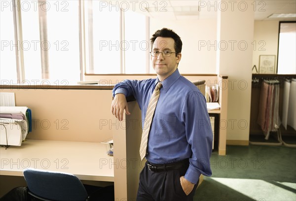 Businessman standing by office cubicle