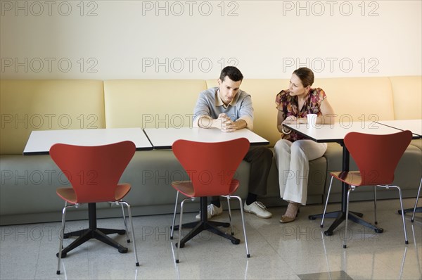Coworkers having discussion in office cafeteria