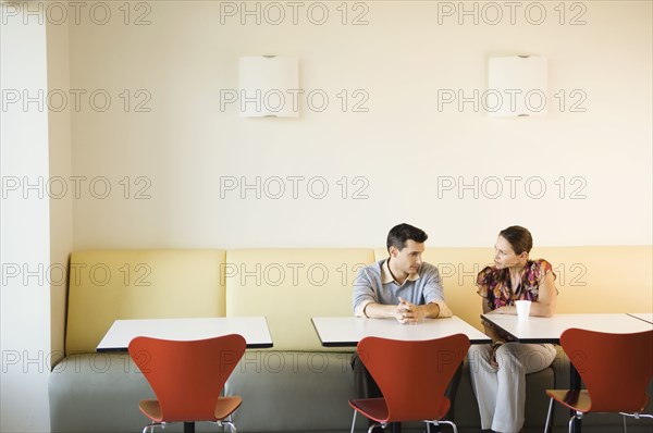 Coworkers having discussion in office cafeteria
