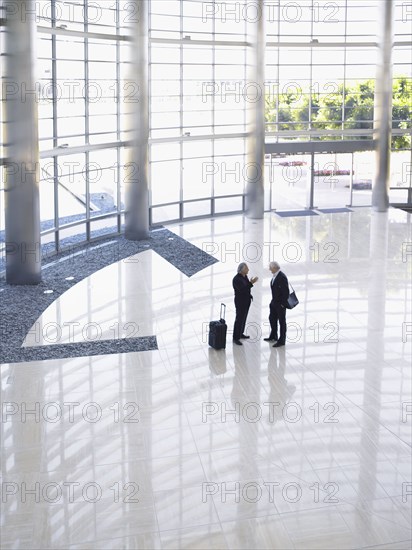 Two businessmen talking in lobby