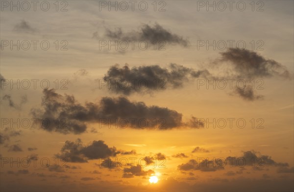 Golden sunrise sky with clouds and sun