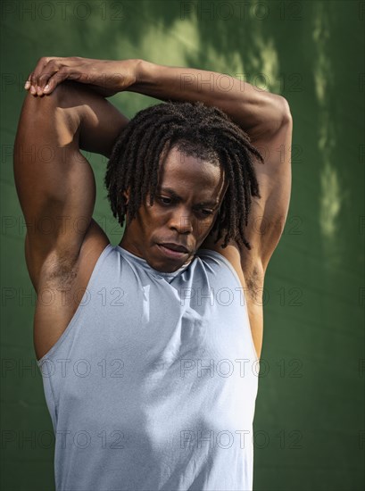 Man stretching arm outdoors