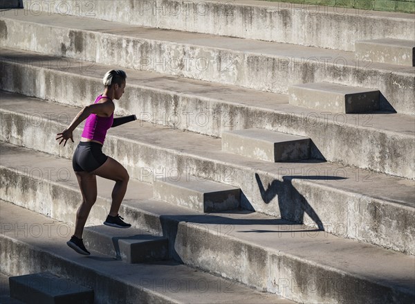 Woman with amputated hand jogging up steps