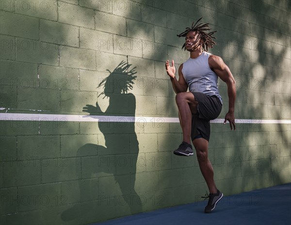 Athletic man jumping next to wall