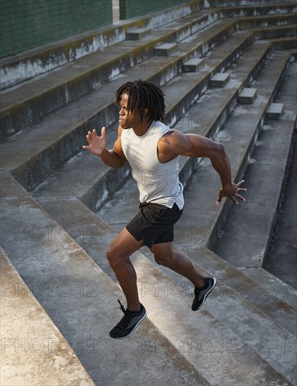 Athletic man running up steps