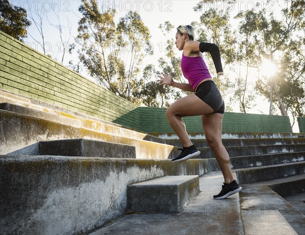 Athletic woman with amputated hand running up steps