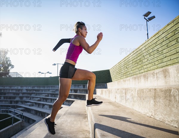 Athletic woman with amputated hand running up steps