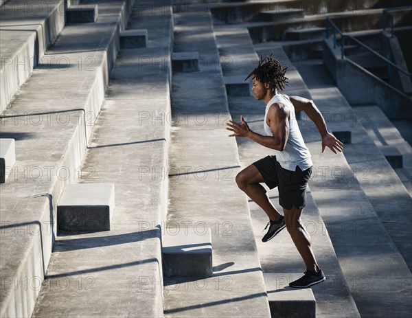 Athletic man running up steps