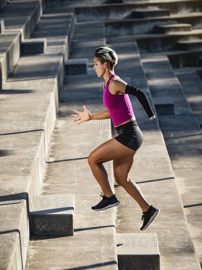 Athletic woman with amputated hand running up steps