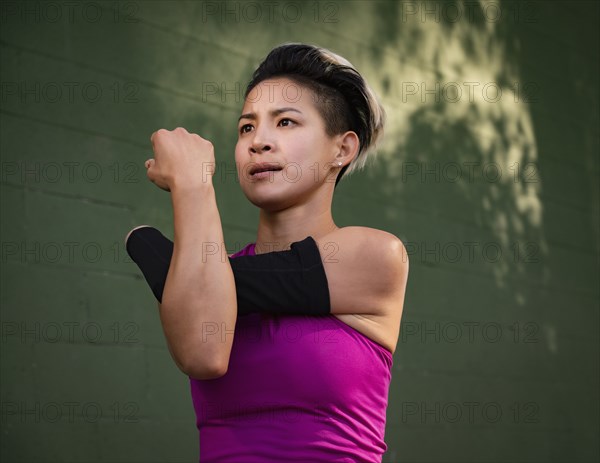 Athletic woman with amputated hand stretching arm