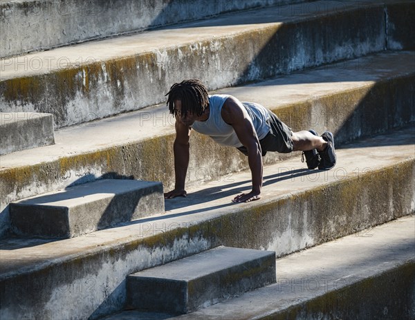 Athletic man doing push-ups on steps