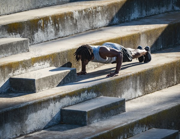 Athletic man doing push-ups on steps