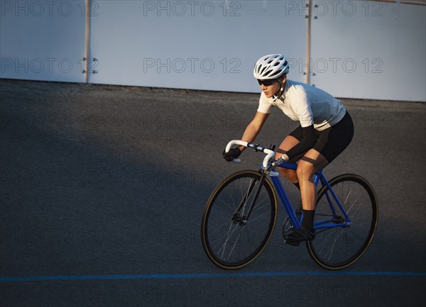 Athletic woman with prosthetic arm riding bicycle