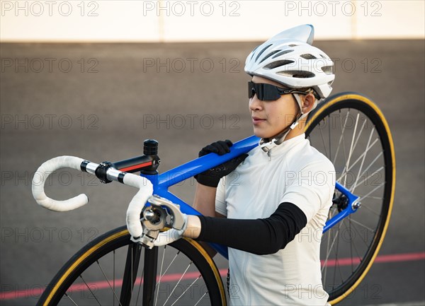 Athletic woman with prosthetic arm carrying bicycle