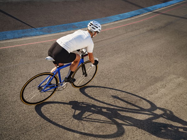 Athletic woman with prosthetic arm riding bicycle