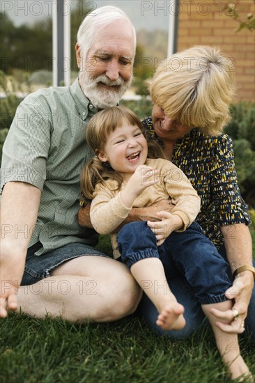 Smiling grandparents with granddaughter