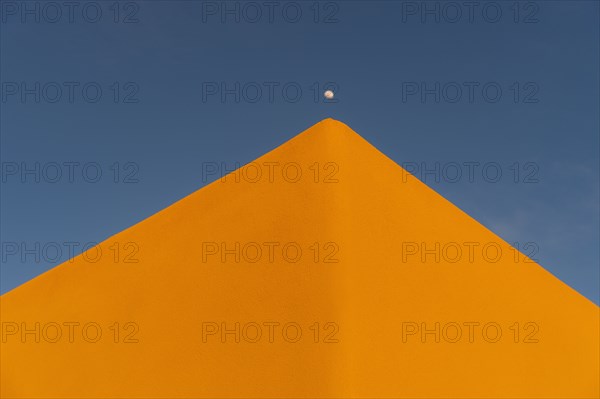 Moon over adobe pueblo building