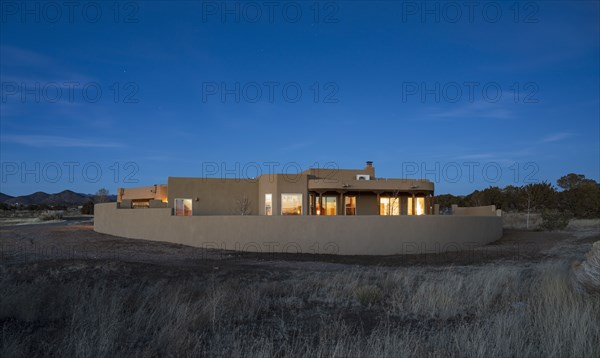 Pueblo style house in landscape at dusk